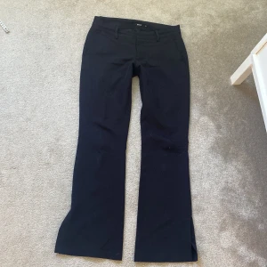 Lågmidjade kostymbyxor  - Svarta kostymbyxor från BikBok i storlek 36. Byxorna har bootcut-modell med utsvängda ben, hällor för bälte och klassiska fickor fram. Midjemått 37cm och innerbensmått 76cm 