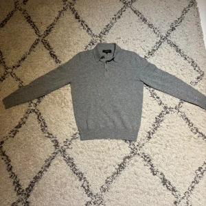 Grå pikétröja - Klassisk grå pikétröja från Lawrence Grey i 100% kashmir. Mycket bekväm att ha på sig och passar perfekt för sommarkvällar men även nu inför hösten. Utmärkt skick, använd fåtal gånger. Vid frågor, hör av dig! 