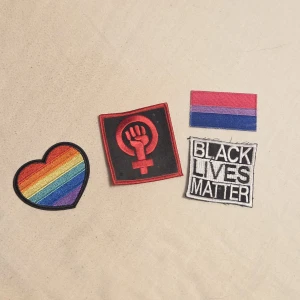 fyra pride feminist tygmärken/patches - bisexuell flagga, regnbågshjärta, blm kan man stryka på. feministmärket måste sys på. alla för 20!