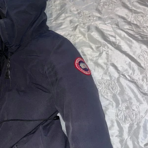 Canada Goose jacka - Säljer en svart dunjacka från Canada Goose .Fodrad med dun och har dragkedja .pälsen följer med och går att ta bort. storleken går att justeras inuti jackan (passar xs/s). Köptes för en månad sen för 5000kr.                                                            ‼️pris går att diskuteras.            Den är ÄKTA