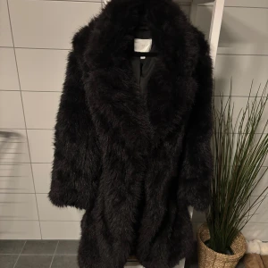 Svart pälsjacka - Jackan har varit väl omhändertagen och är i nytt skick då den endast använts en gång.