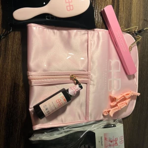 Hello Bombshell Halo löshår kit svart - Hello Bombshell starter pack med Halo löshår 20” i svart äkta hår, borste för extensions, två rosa krokodilklämmor, split end serum, galge och rosa travelbag. Perfekt för dig som vill ha längre och fylligare hår snabbt och enkelt. Nypris 2998kr helt nytt 