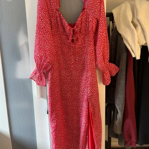 Röd blommig långklänning med slits - Säljer denna superfina blommiga sommarklänningen eftersom att den är för stor för mig. Lappen är borta så jag vet inte storleken men skulle gilla på s-m🥰