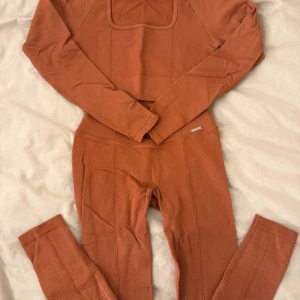Rostfärgade seamless set Aim'n - Säljer rostfärgade seamless set från Aim'n. De har hög midja, tight passform och är gjorda i ett stretchigt, strukturerat material som känns mjukt mot huden. Perfekta för träning eller chill. Snygg Aim'n-detalj i metall på höften.