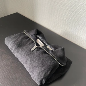 Svart half zip tröja Jack & Jones - Svart tröja från Jack & Jones med half zip-dragkedja i silver. Klassisk och enkel design med hög krage. Perfekt för lager-på-lager och chill stil. Mjuk känsla, troligtvis i bomull eller polyesterblandning.