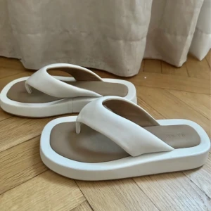 Filip Flop NA-KD - De här flip-flopsen är gjorda av PU och har breda remmar. De har rundade tår och vadderade, grova sulor. Klackhöjd 3 cm.  Använd 1–2 gånger. Storlek 37.