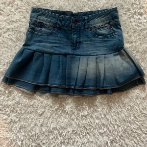Blå jeanskjol med volang  - En jeanskjol omsydd från ett par jeans. Midjemått tvärsöver - ca 40cm Längd - 38cm