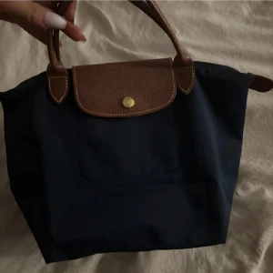 Longchamp väska - Säljer mina longchamp väska då den inte kommer till användning. Den är äkta, skriv för fler bilder. Supertrendig stockholmsstil väska i strlk S. I nästan nyskick.