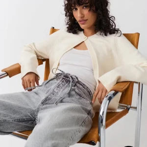 Krämvit kofta från Gina Tricot - Krämvit kofta med rund hals och enkel knapp framtill från Gina Tricot. Långärmad och i mjuk stickad bomull, perfekt att slänga över ett linne eller t-shirt. Enkel och clean design som funkar till jeans eller kjol.