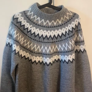 Stickad tröja  - Grå stickad tröja med mönster. Storlek M från lager 157. Aldrig använd så prislappen finns kvar! 