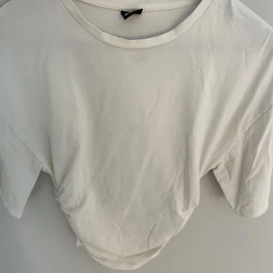 Vit basic t-shirt från Gina Tricot - Enkel och stilren vit t-shirt från Gina Tricot i mjuk bomull. Klassisk rund halsringning och korta ärmar, perfekt till jeans eller kjol. Snygg passform och lätt att matcha med allt i garderoben. Lite små fläckar här o där som går bort med rätt medel.