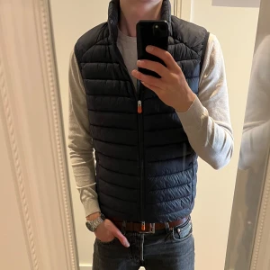 Mörkblå dunväst från Save The Duck - Säljer en mörkblå dunväst från Save The Duck i storlek M. Skriv vid eventuella frågor! Mycket bra skick! Ej använd länge. 