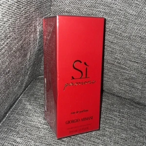 Sì Passione parfym 100ml Armani - Säljer en lyxig parfym, Sì Passione från Giorgio Armani. Flaskan är på 100 ml och kommer i en snygg röd kartong med gulddetaljer. Eau de parfum med intensiv och modern doft, perfekt för dig som gillar elegans och stil.k