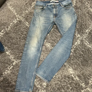 Ljusblå jeans från Peak Performance - Säljer ett par ljusblå jeans från Peak Performance i klassisk femficksmodell. Jeansen har raka ben, normal passform och snygga slitningar framtill för en avslappnad look. Tillverkade i mjukt denimtyg med dragkedjegylf och läderpatch bak.