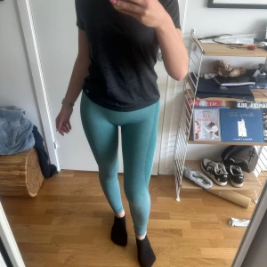 Turkosa seamless leggings - Säljer ett par turkosa seamless leggings med hög midja. De är tighta och stretchiga, perfekta för träning eller chill. Materialet är mjukt och följsamt, och färgen är en snygg ljus turkos med melerad effekt. Finns tyvärr en stor reva i rumpan, därav priset