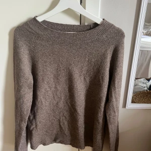 Brun stickad tröja med rund hals - En enkel och stilren brun stickad tröja med rund halsringning och långa ärmar. Perfekt för lager-på-lager och passar till både jeans och kjol. Tröjan har ribbade muddar vid hals, ärmslut och nederkant för en snygg finish.