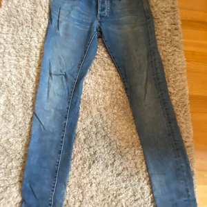 Blå skinny jeans från Neuw, W31 L32 - Säljer ett par blå skinny jeans från Neuw i klassisk tvätt. Jeansen har fem fickor, bälteshällor och snygga slitningar. Modellen är tight och sitter riktigt schysst på benen. Perfekta för dig som gillar en smal siluett och vill ha ett par stilrena jeans.