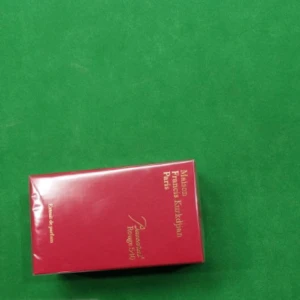Baccarat Rouge 540 Extrait de Parfum - Lyxig parfym från Maison Francis Kurkdjian, Baccarat Rouge 540 Extrait de Parfum. Kommer i en elegant, röd och glansig kartong med guldfärgad text. Förpackningen är rektangulär och utstrålar exklusivitet och stil.