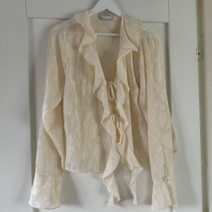 Blus från Nelly - En tunn blus från Nelly som knappt är använd, knyt mellan volangen där fram och luftig i modellen. Storlek står ej men passar mig som vanligtvis är M/S