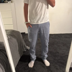 Ljusblå linnebyxor  - Säljer ett par ljusblå linnebyxor med avslappnad passform och resår i midjan. Byxorna har sidfickor och en enkel knappdetalj. Perfekta för chill dagar eller när du vill ha något svalt och skönt på dig. Byxorna är köpta i Italien så märke är oklart men de kostade ca 75 euro kronor. Säljs då de inte andvänds