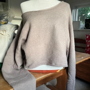 Beige stickad tröja - Supermjuk beige stickad tröja med långa ärmar. Jättesnygg att hasa ner på axeln. Den är lite croppad så den passar perfekt att kombinera med ett längre linne att ha under