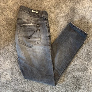 Dondup George - Säljer dessa riktigt snygga grå jeans från Dondup i modellen George. Perfekta för dig som vill ha en modern och avslappnad stil. Skick: 8/10 inga synliga defekter men använda💯Modellen på bilden är ca 185cm lång‼️Tveka inte på att kontakta om du har några frågor eller funderingar🙏