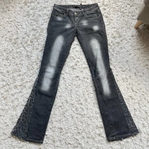 Grå bootcut jeans med leoparddetal - Snygga lågmidjade grå jeans med coola fickor, omsydda nedtill med leopard mönster 💓 midjemåttet rakt över är 37 cm o Innerbenslängden är 81 cm, skriv vid frågor!