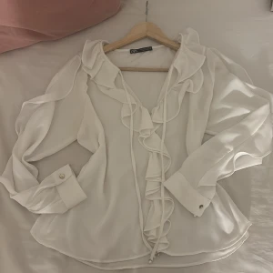 Vit Blus med volanger från Zara - Snygg vit blus från Zara oanvänd !!den var tyvärr för stor för mig