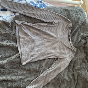 Grå ribbad långärmad tröja Bik Bok - Säljer en grå ribbad långärmad tröja från Bik Bok i storlek S. Tröjan har v-ringning och är i mjukt, stretchigt material som sitter snyggt på kroppen. Perfekt att matcha med jeans eller kjol för en chill look.