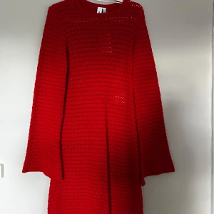 Röd virkad kortklänning från Something New - Superfin röd virkad kortklänning med lång ärm från Something New. Klänningen har en luftig, stickad känsla och rund halsringning.