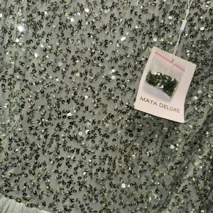 Ljusgrön paljettklänning Maya Deluxe - Superfin långklänning från Maya Deluxe i ljusgrönt med glittriga paljetter på överdelen och ärmarna. Kjolen är i mjuk, plisserad tyll som ger ett drömmigt fall. Perfekt för dig som vill sticka ut med extra glitter och elegans.