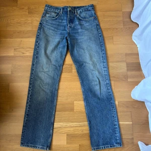 Blå raka jeans från Zara, strl 38 - Klassiska blå jeans från Zara i rak modell med normal passform. Jeansen har fem fickor, knappgylf och är tillverkade i slitstarkt denim. Perfekta till sneakers eller boots för en chill look.