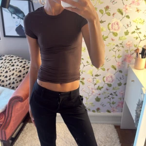 Topp från Gina🤎 - Säljer en brun, tight och croppad topp med korta ärmar och rund halsringning. Den är från Gina tricot i stl xxs🤎🤎🤎