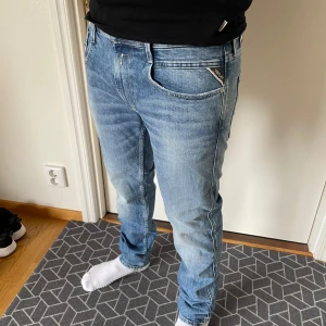 Nya Replay Jeans - Säljer ett par snygga Replay Anbass jeans i ljusblå tvätt. Jeansen är helt nya med lapparna kvar. Storleken är 34/32. Obs sömen har gåt upp på benet men det syns inte när man har på sig dem. Priset är ej hugget i sten🤗