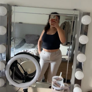 Beiga kostymbyxor från NaKd  - Säljer ett par stilrena beiga kostymbyxor med raka ben. Byxorna har hällor för bälte, fickor fram och dekorativa fickor bak. Perfekta för en clean och snygg look. Passar dig som gillar klassisk stil med modern touch. Använda 1 gång, därav i nytt skick. 