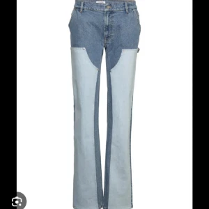 Filippa K tvåfärgade jeans - Unika jeans från Filippa K i två olika blå denimtoner. Modellen har hög midja, raka ben och cool patchwork-design framtill. Tillverkade i 98% ekologisk bomull och 2% elastan för en skön passform. Perfekta för dig som vill sticka ut med din stil.