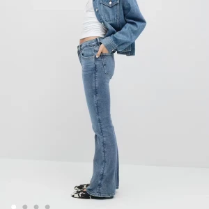 Mid waist bootcut jeans  - Blåa mid waist bootcut jeans från Gina 