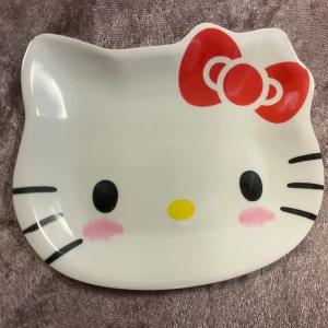 Hello Kitty Tallrikar  - Bilderna visar tre olika Hello Kitty-tallrikar i olika färger och mönster, perfekta för dig som älskar söta och trendiga prylar. Tallrikarna har den ikoniska Hello Kitty-designen och passar både till snacks och dekoration. Perfekt för att göra vardagen lite roligare!  65kr/st , samma frakt 