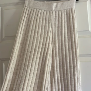Beige ribbade wide byxor - Supermjuka och ribbade byxor i beige med bred resår i midjan. De har en loose och wide passform som ger en chill vibe. Perfekta för dig som gillar bekväma och snygga plagg. Materialet känns som bomull eller syntet och de är helfärgade utan mönster från only storlek xs