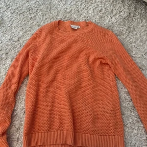 Orange stickad tröja från Vila - Säljer nu denna orange stickad tröja från Vila i storlek S. Tröjan har en grovstickad struktur, rund halsringning och långa ärmar. 
