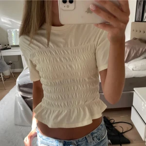 Ljusgul smockad blus  - Supersöt ljusgul blus med smockad midja och volangkant nertill. Använd en gång 💓passar xs,xxs första bilden lånad 