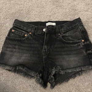 Svarta jeansshorts med fransad kant - Snygga svarta jeansshorts från Perfect Jeans med fransad kant och klassisk femficksmodell. Shortsen har dragkedja, knapp och bälteshällor. Perfekta för sommaren och ger en cool vibe till din outfit. Passar mig som vanligtvis använder 34