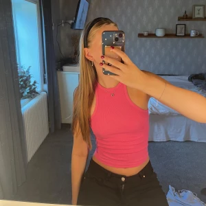 Rosa ribbad linnetopp - Säljer en snygg rosa ribbad linnetopp med croppad passform. Toppen är ärmlös med klassisk racerback och sitter tight mot kroppen. Perfekt för dig som gillar en enkel men trendig stil.