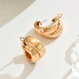 Guldiga örhängen - Säljer ett par chunky örhängen i guld med snygg tvinnad och rundad form. De är riktigt statement och har en blank finish som ger en lyxig vibe. Perfekta för dig som gillar att sticka ut med accessoarer och vill ha något som syns. Helt oanvända och ska vara rostfria.
