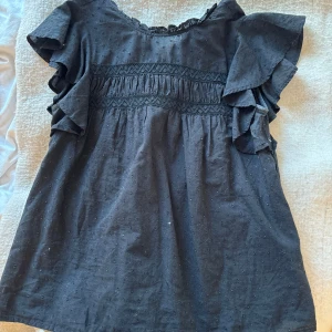 Svart topp - Säljer denna svarta toppen/blusen från vero Moda då den inte används! Tröjan är i mycket bra skick och är använd några få gånger. Säljer för 130!🥰🥰