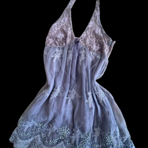 Babydoll top <3 - Supersöt kortklänning från Odd Molly i ljuslila och beige med spets upptill och broderade blommor. Toppen har omlottknytning i nacken, v-ringad hals och pärldetaljer längs nederkanten. Materialet är mjuk polyester och spets, perfekt för sommarens alla tillfällen.