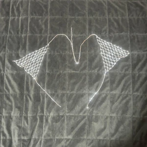 Vintage Rhinestone Bralette – Statement Piece - Unik och glittrande bralette i nätmönster med glittrande strass och justerbara kedjor. Perfekt för festival, scen, fotoshoot eller att bära ovanpå en topp/klänning för en riktig wow-effekt. 	•	Justerbar passform 	•	Lätt men hållbar design 	•	Strålar lyx och glamour One size (passar ca XS–M, justerbar i nacke och rygg)  Skick: Mycket fint, endast använd vid ett tillfälle.  Pris: 149 kr (nypris ca 600 kr)