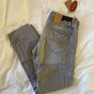Grå tapered jeans från edc, W33 L32 - Snygga grå jeans från edc med tapered fit och klassisk femficksdesign. Byxorna har bälteshällor, knappgylf och är gjorda i mjukt bomullsmaterial. Perfekta för dig som gillar en stilren och avslappnad look.