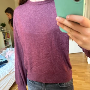 Vinröd stickad tröja med rund hals - Mysig vinröd stickad tröja i storlek S med rund hals och långa ärmar. Tröjan har ribbade muddar vid ärmslut och nederkant, vilket ger en snygg och enkel look. Perfekt för dig som gillar basic men ändå vill ha lite färg i garderoben.