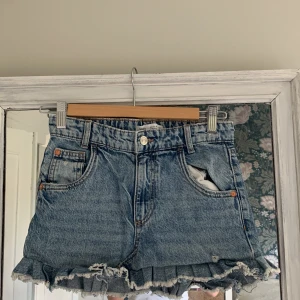 Blå jeansshorts med volang från Zara - Säljer en blå jeans kjol från Zara som jag sytt om själv, från ett par vida jeans och med en volang längst ner, kommer att strykas innan den skickas!